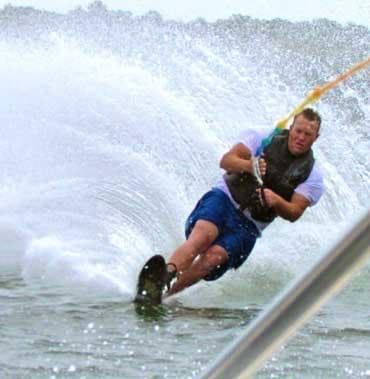 Waterskier carving sharp turn, spraying water in ocean