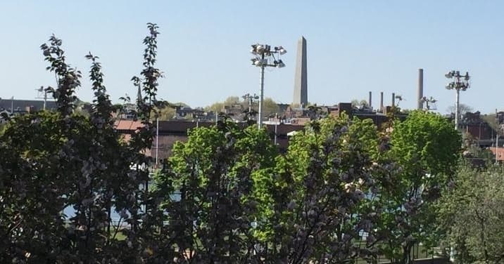 Panoramic view of Boston skyline with Bunker Hill Monument and trees
