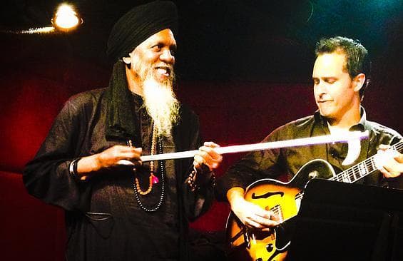 Two jazz musicians performing on dimly lit indoor club stage
