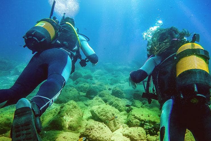 Scuba divers exploring vibrant coral reef in tropical ocean