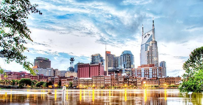 City skyline reflected on river at golden hour, urban waterfront