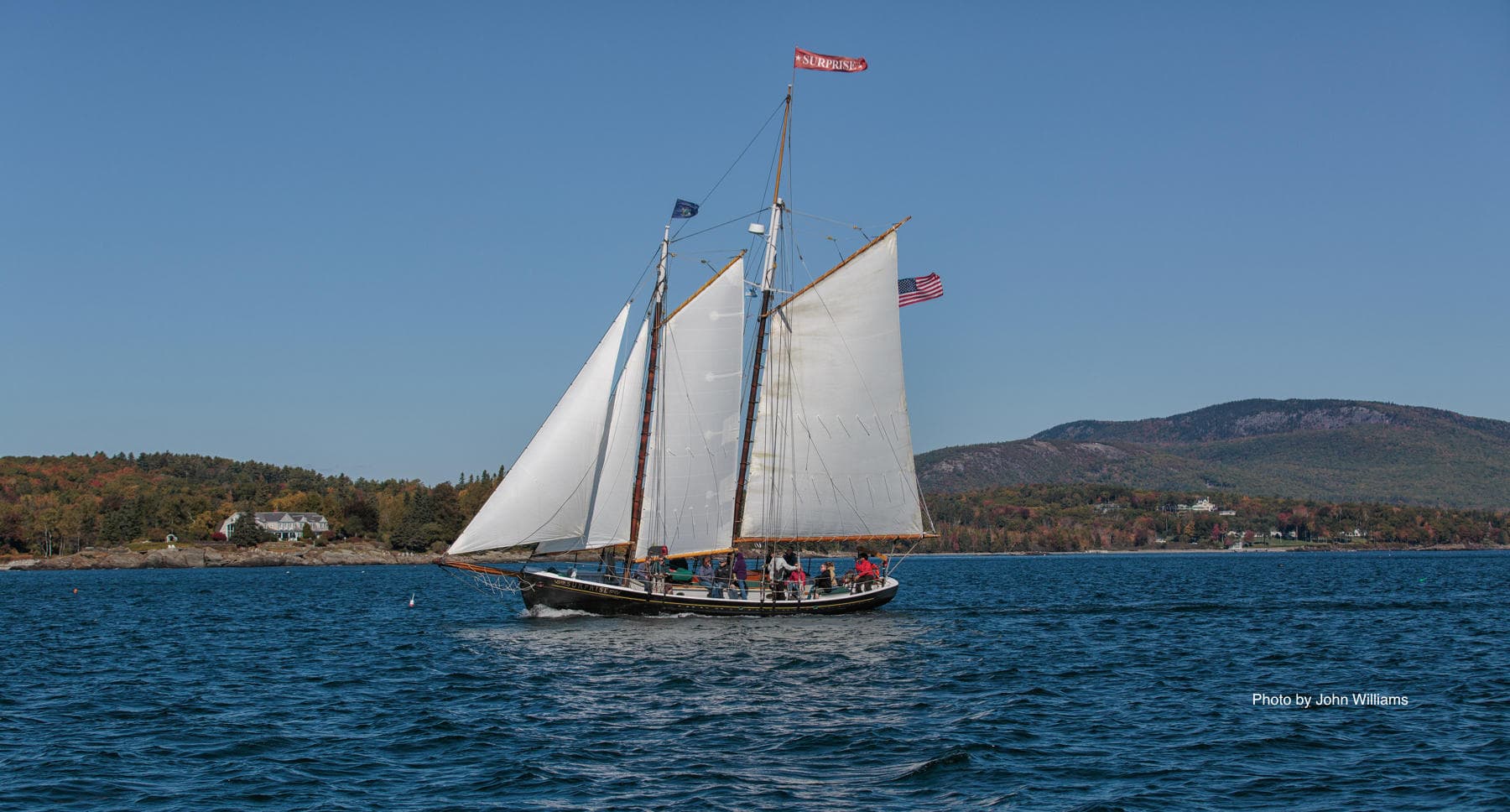 Classic schooner under full sail cruising along coastal waters