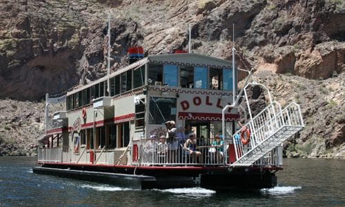 Paddlewheel riverboat Dolly cruising rocky canyon with passengers