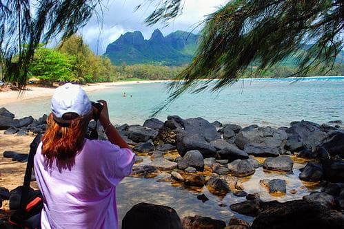Tropical lagoon shore with photographer capturing coastal peaks
