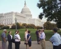 Visitors standing near US Capitol lawn on guided tour