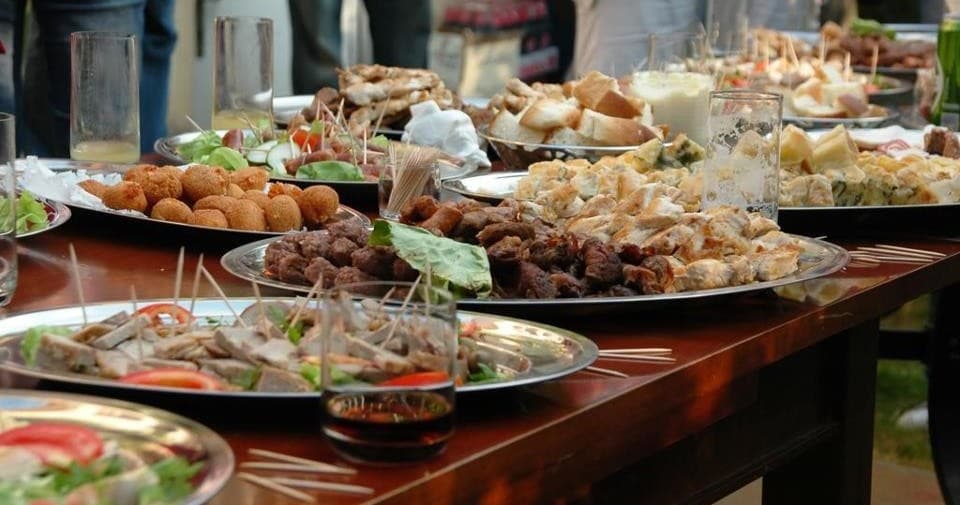 Tapas and platter spread on long table at indoor food tasting