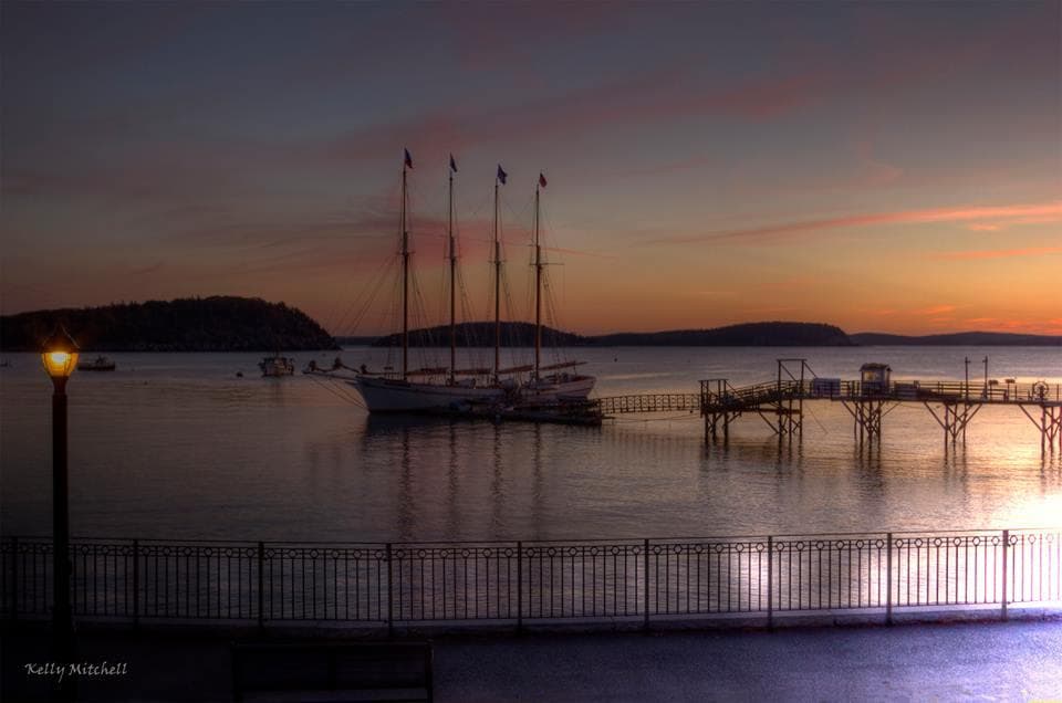 Sunset harbor with moored schooners and calm waters, coastal Maine