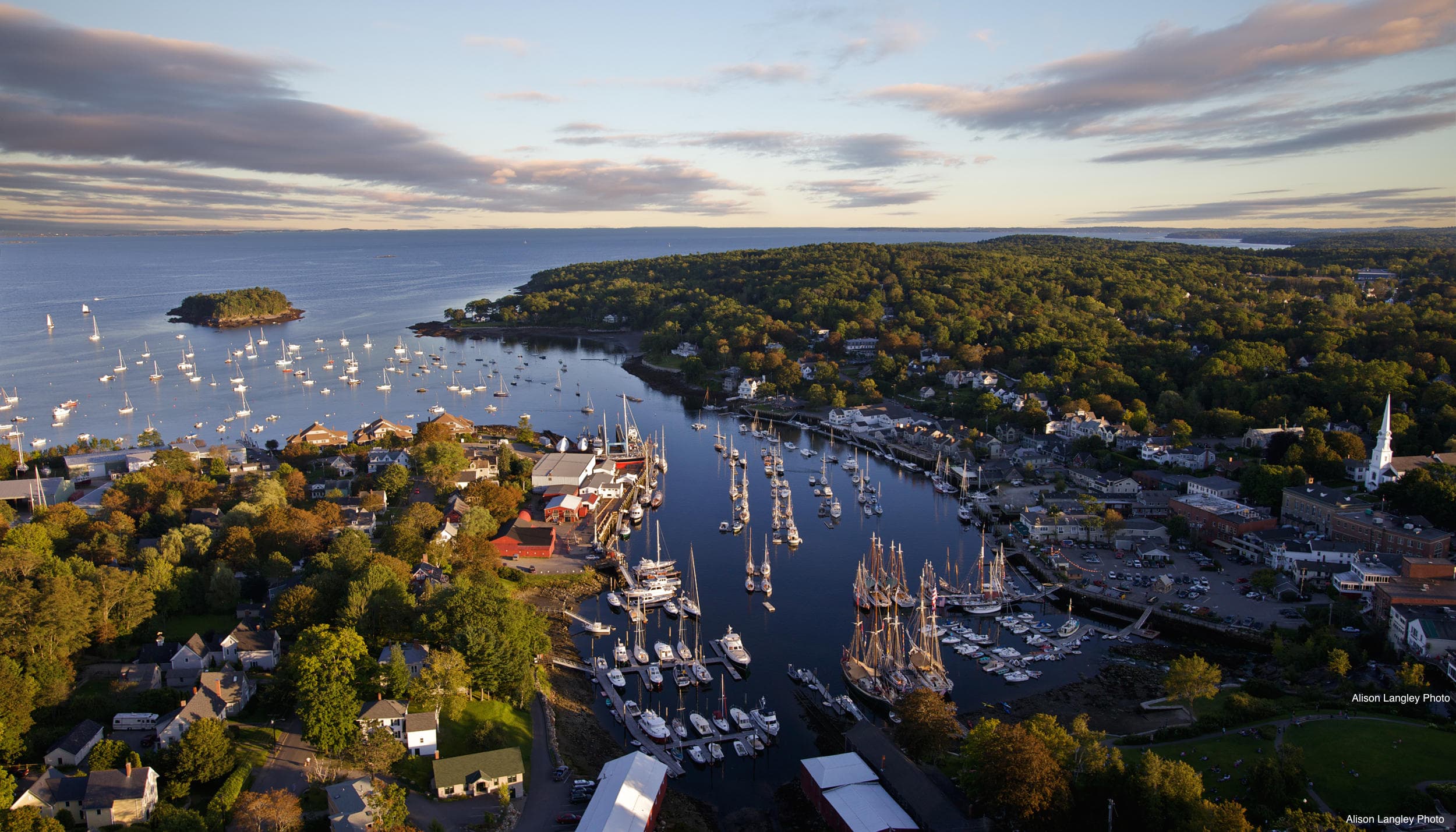Aerial panorama of coastal harbor filled with sailboats and islands