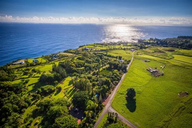 Aerial coastal landscape with ocean cliffs and green farmland