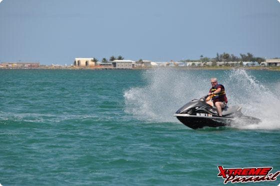 Rider on jet ski racing across turquoise coastal waters