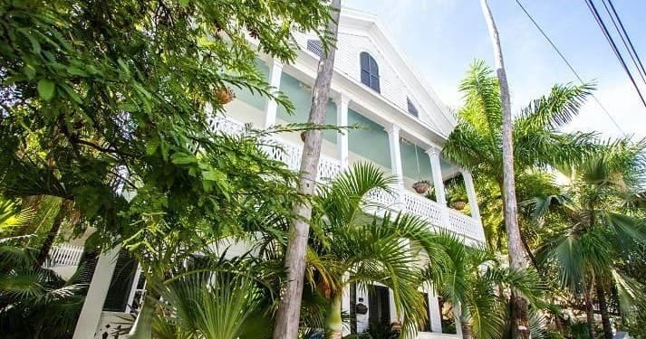 Victorian conch house with palms in Key West daytime facade