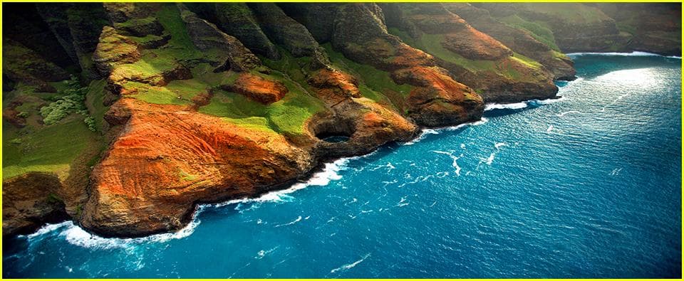 Aerial coastline of Kauai with dramatic cliffs and turquoise ocean