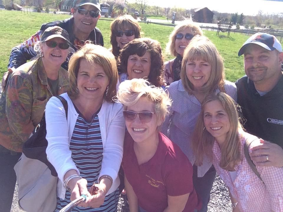 Outdoor group selfie during Finger Lakes wine tour in vineyard