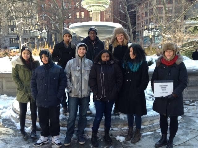 Winter ghost walking tour group posing at snowy city fountain