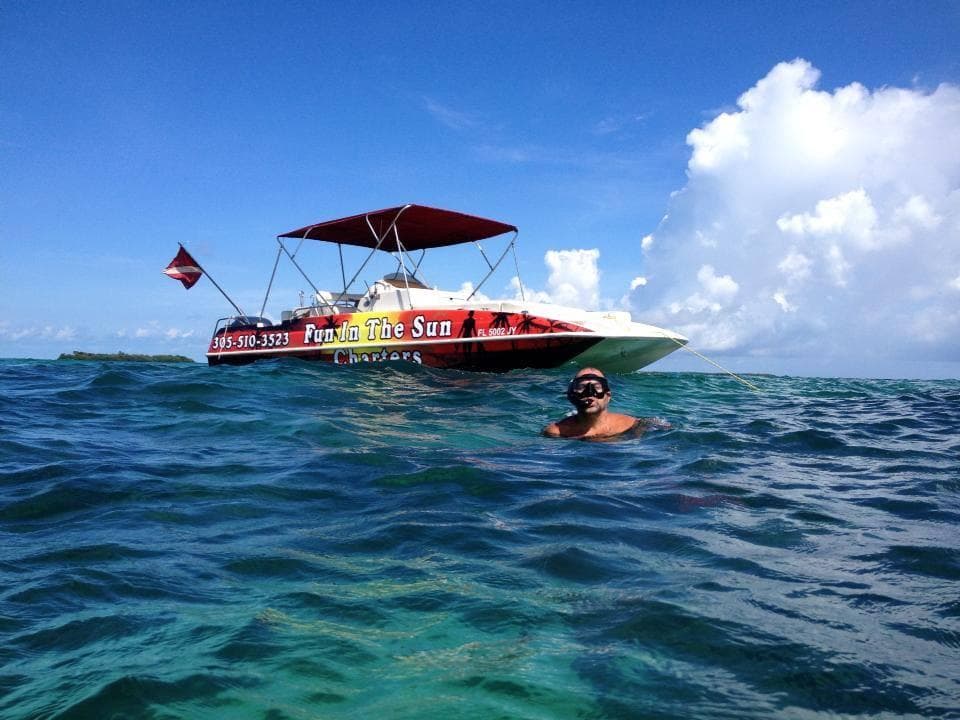 Powerboat cruising offshore with snorkeler in turquoise ocean