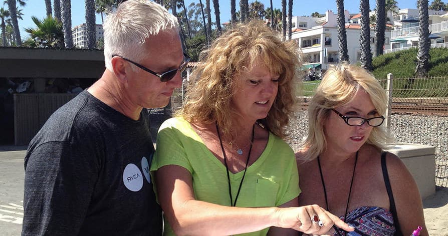 Couple and guide reading clues on coastal promenade