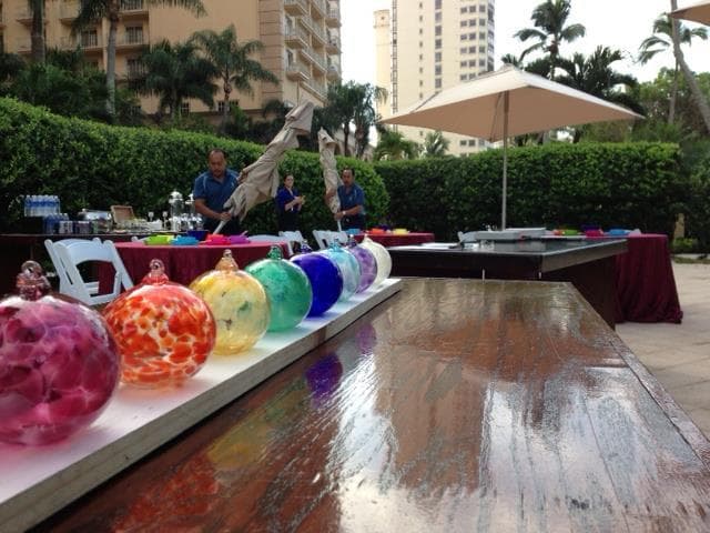 Colorful blown glass orbs displayed on outdoor market table