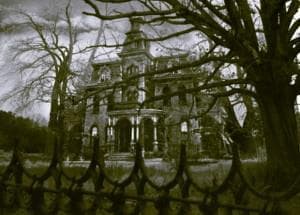 Abandoned mansion exterior framed by bare trees, eerie estate exploration