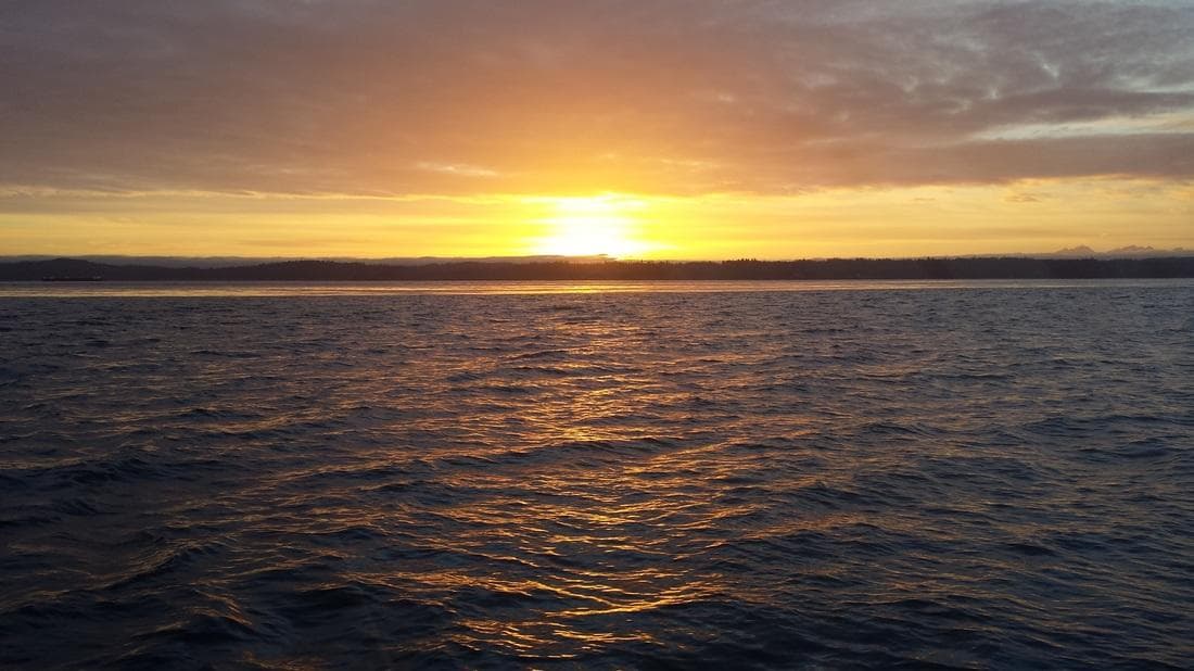 Golden sunset over open water showcasing Candere cruising