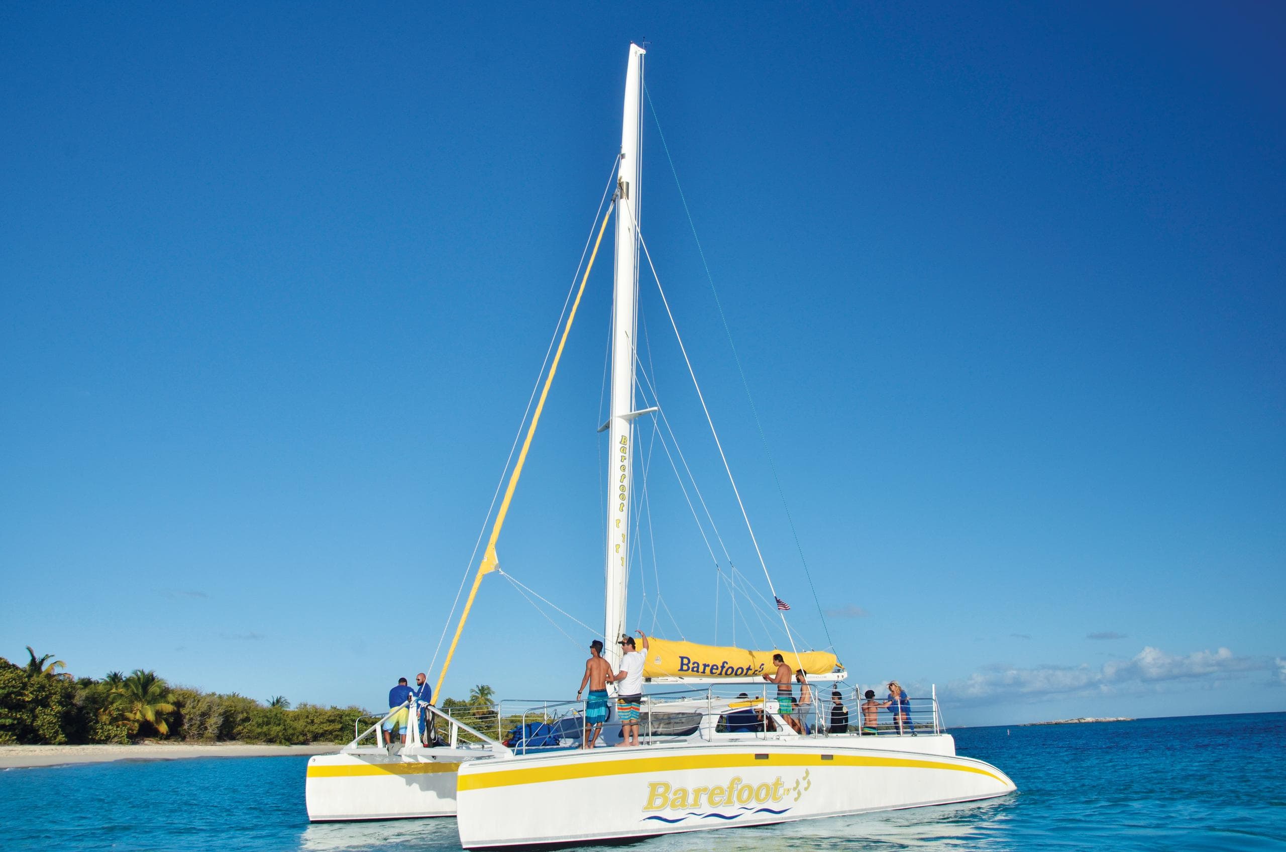 Catamaran sailing on turquoise ocean with blue sky backdrop