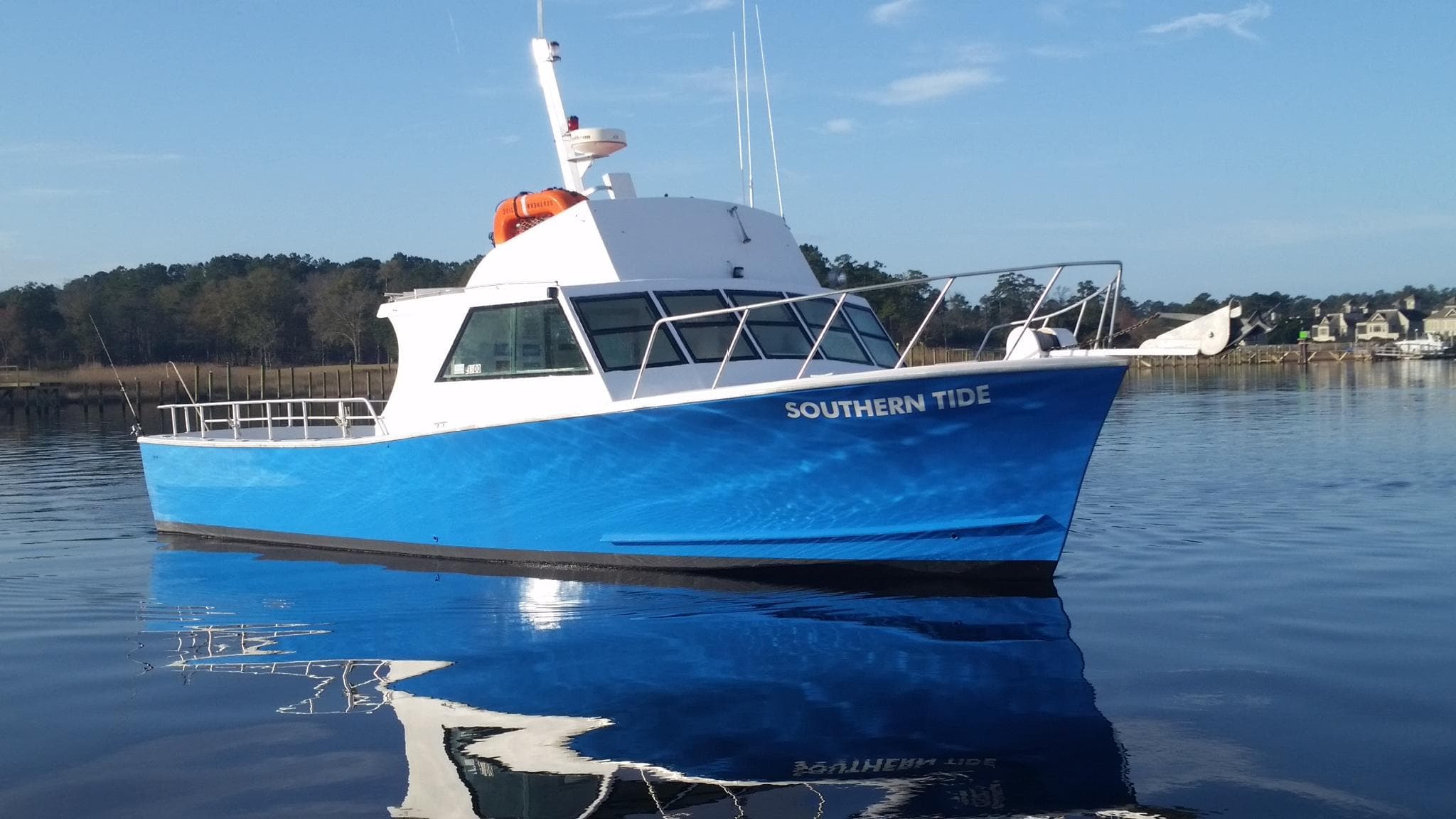 Blue charter boat Southern Tide docked at Little River harbor