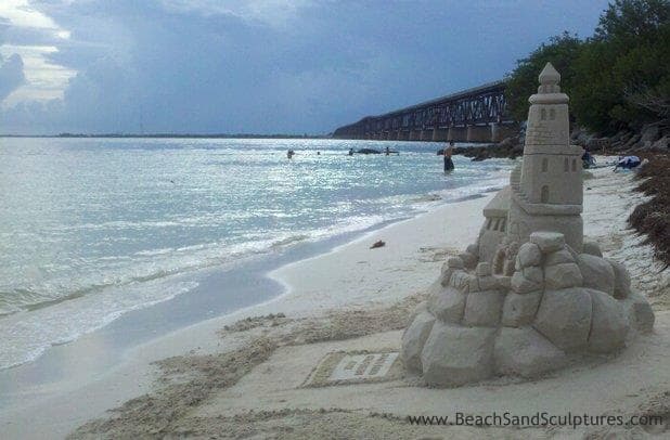 Ornate sandcastle by calm Gulf waters on sandy shoreline