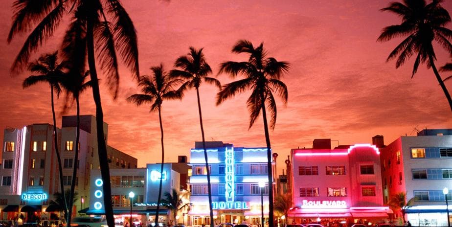 Ocean Drive neon skyline with palm trees at sunset, Miami