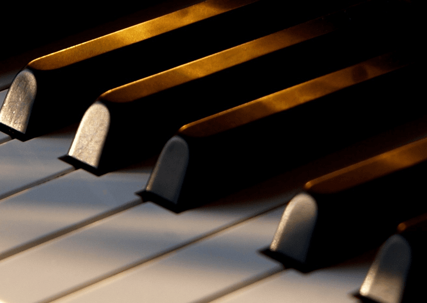 Close-up grand piano keys lit for classical music performance