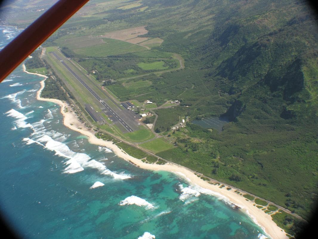 Aerial view of coastline and runway on tropical island shore