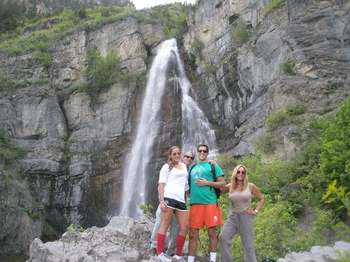 Group posing by dramatic mountain waterfall in Park City