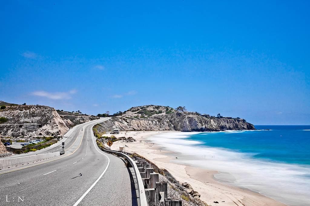 Scenic coastal highway overlooking blue ocean and sandy beach