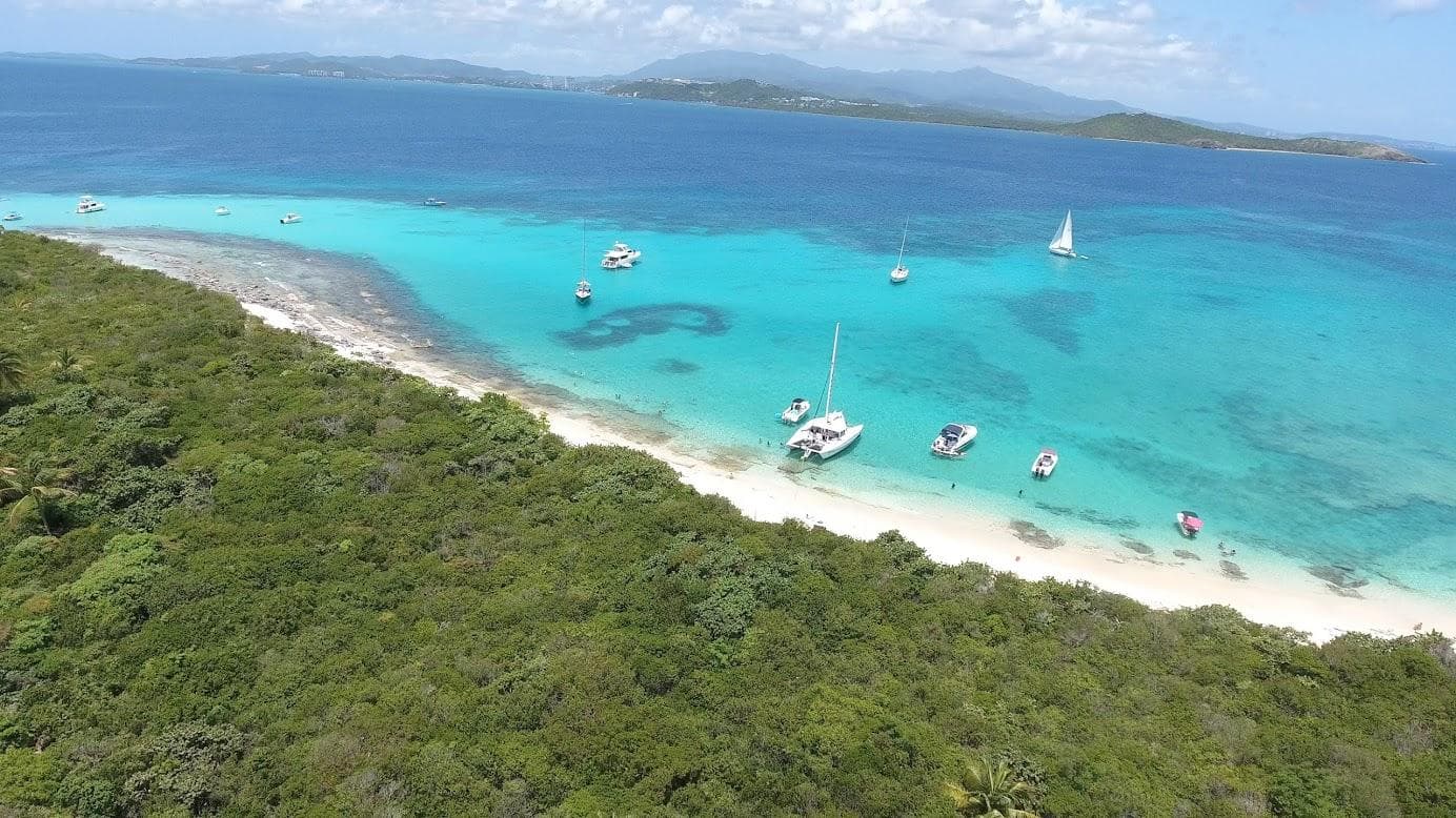 Secluded sandbar and anchored boats along tropical coast