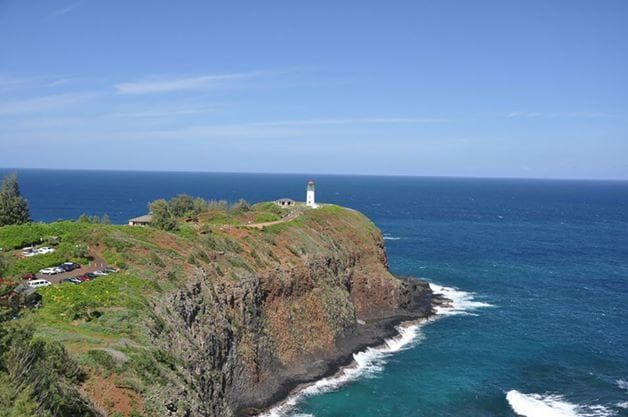 Lighthouse on coastal cliff overlooking blue ocean vistas