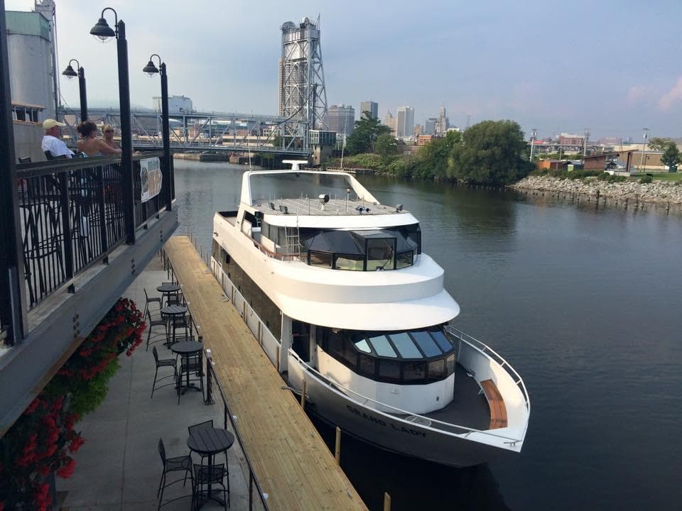 Docked sightseeing yacht at riverside pier in urban harbor