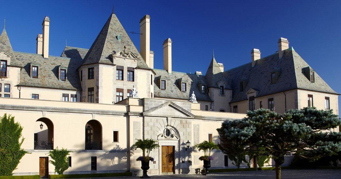 Oheka Castle facade and entrance courtyard beneath clear blue sky, Long Island