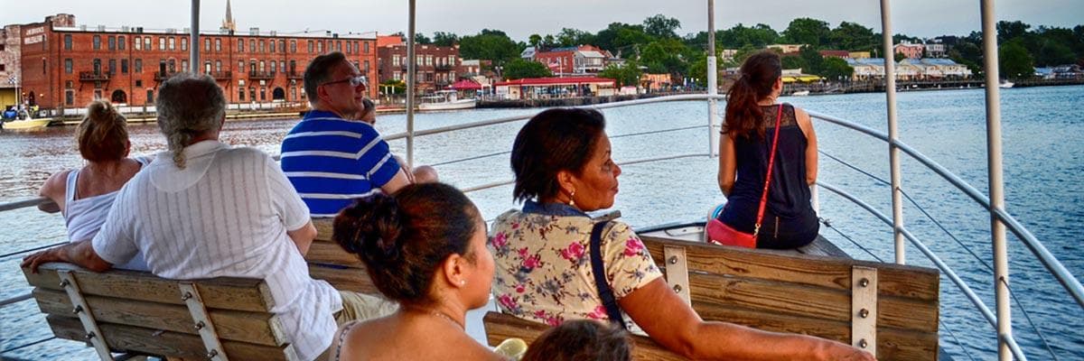 Sightseeing boat tour passengers on coastal harbor deck
