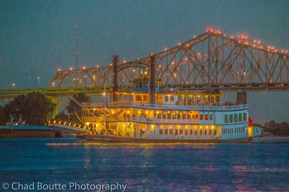 Illuminated steamboat on the Mississippi River at dusk