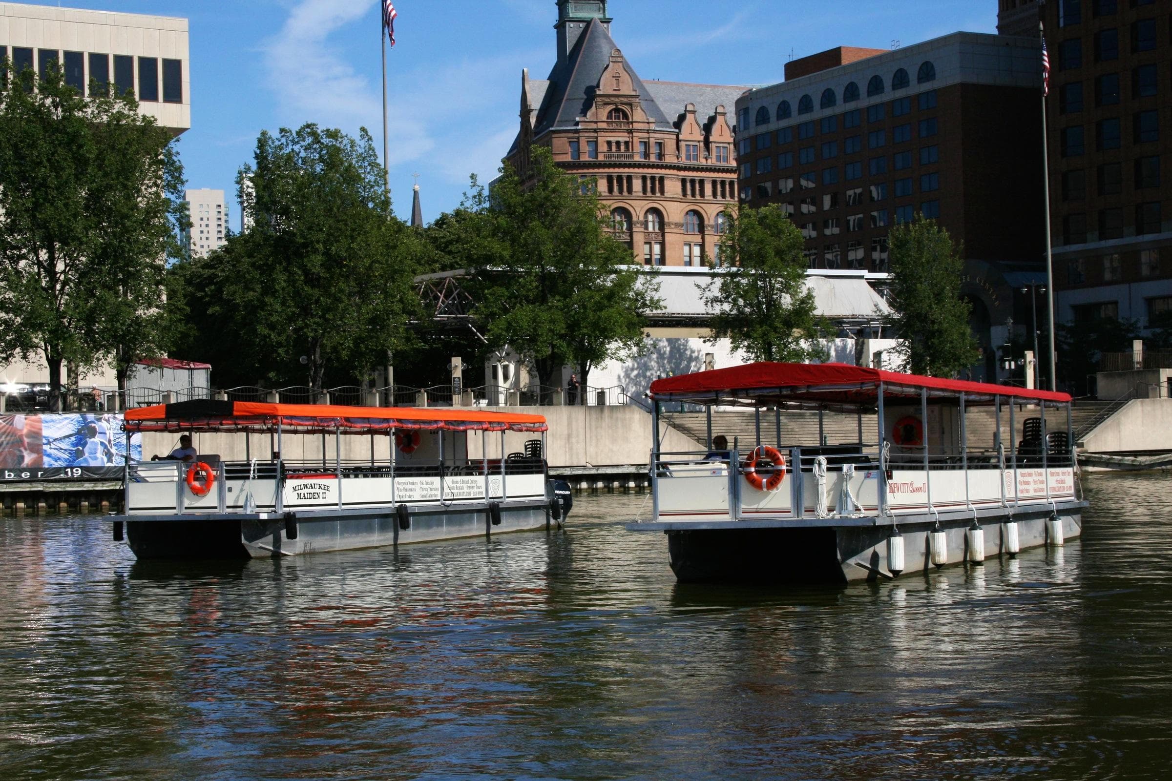 Tour boats docked on riverfront by historic city buildings