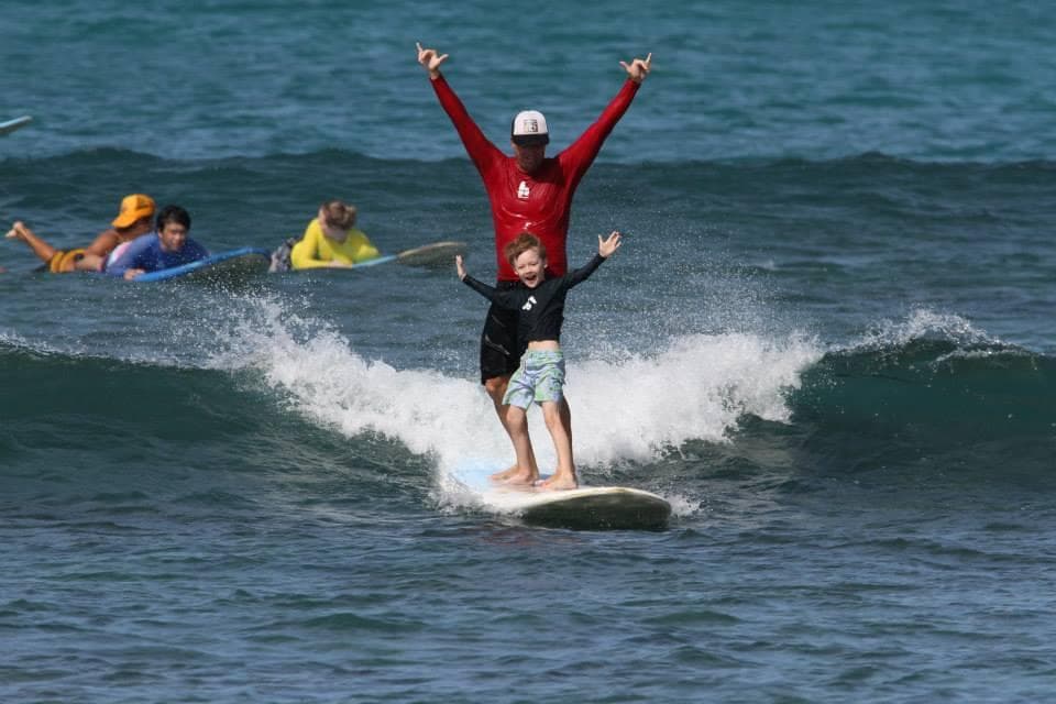 Surfer balancing on longboard riding small clean wave at beach
