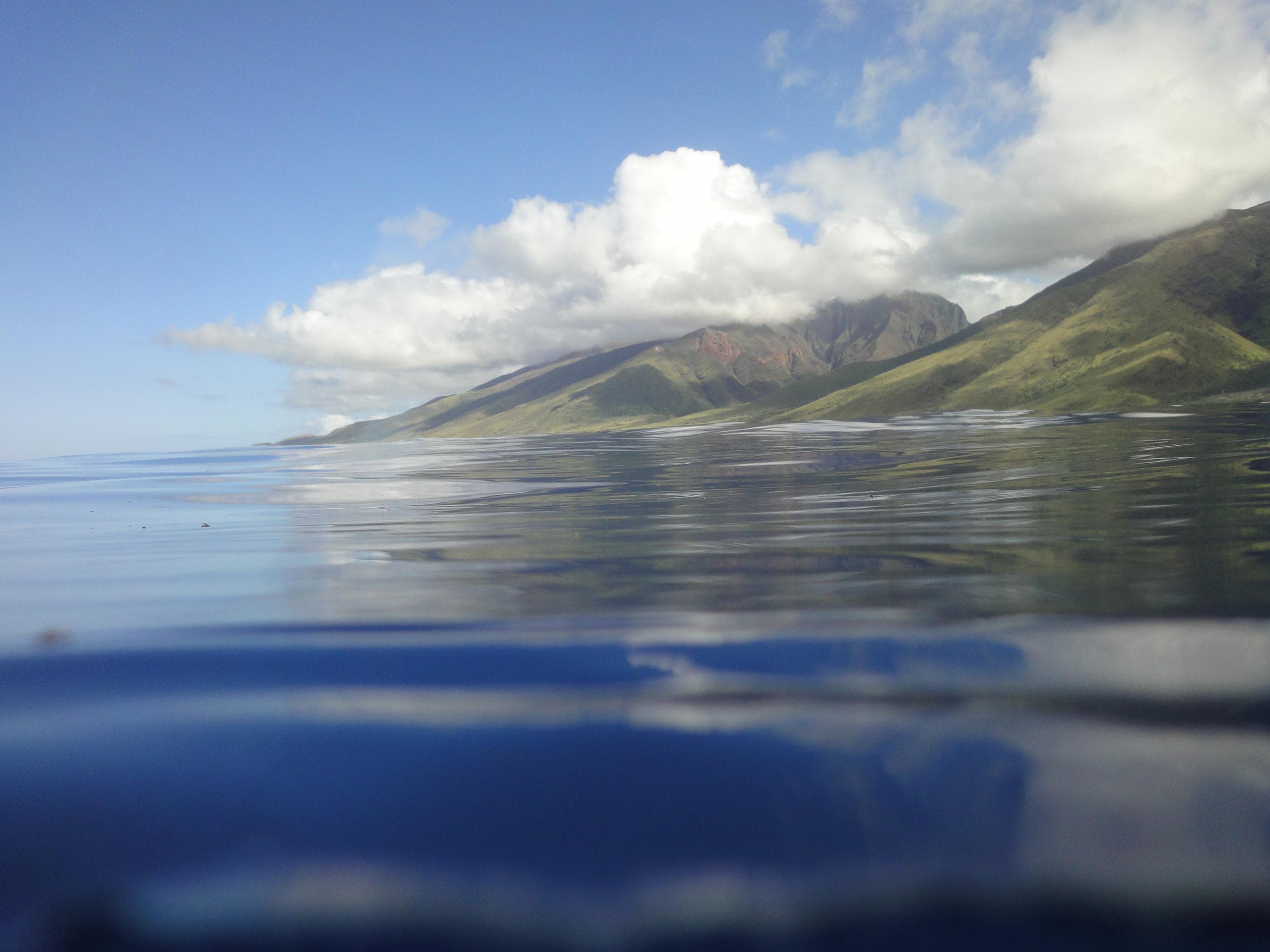 Ocean horizon with mountains and calm water near Maui coast