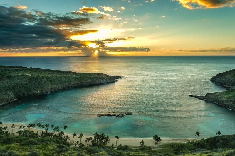 Sunset over tranquil bay with dramatic sky and coastal view