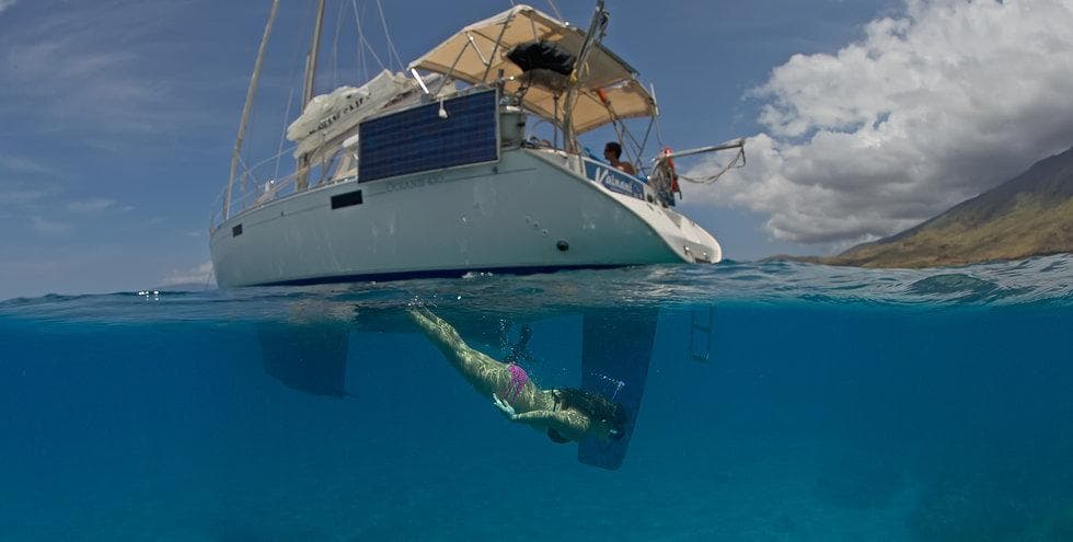 Catamaran with snorkeler underwater in tropical blue sea