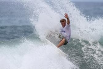 Surfer carving a high spray turn on a powerful Maui ocean wave