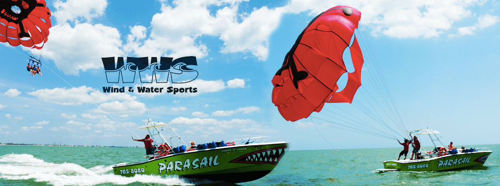Parasail boat cruising near shore, colorful canopy overhead