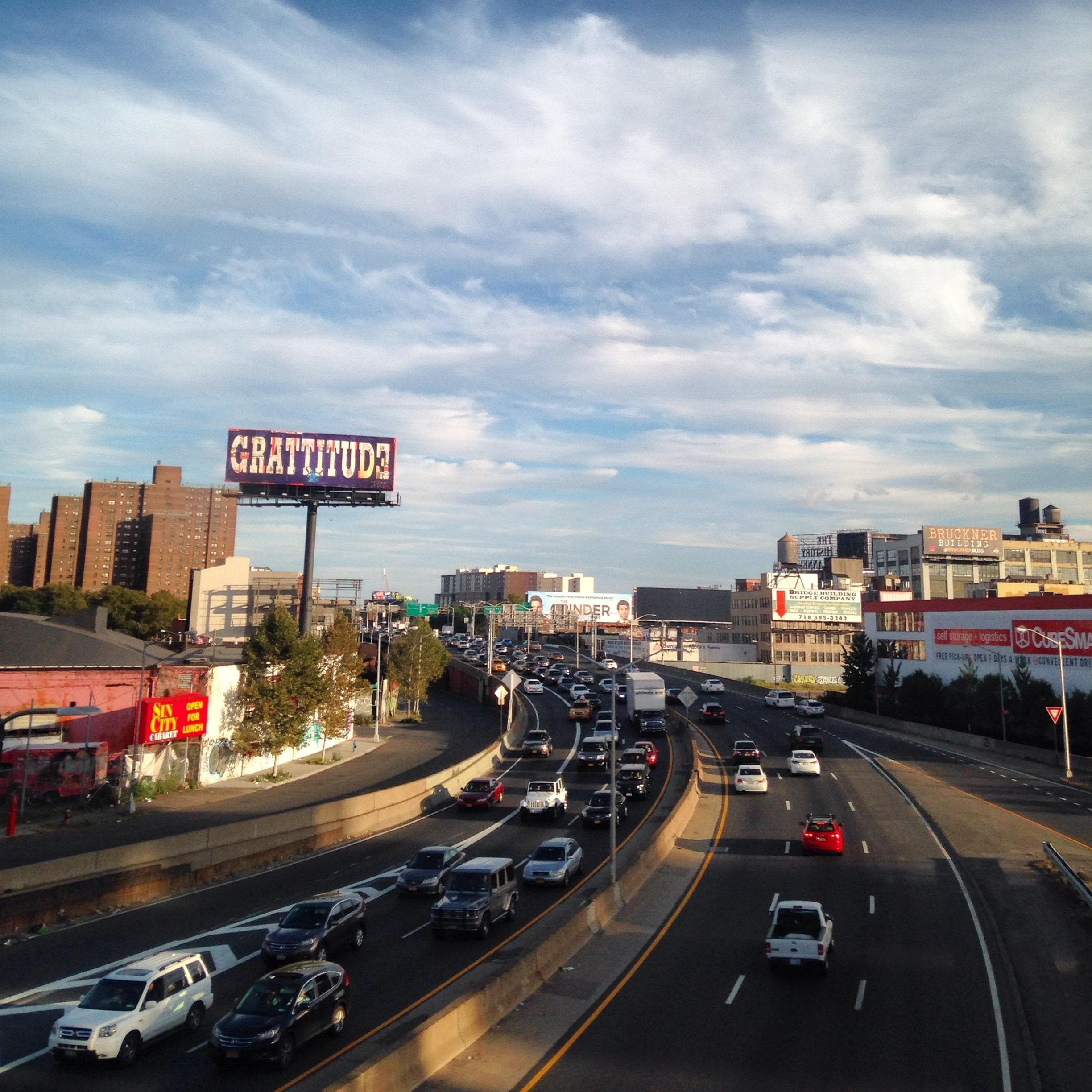 Multi-lane city highway with skyline and dramatic sunset sky