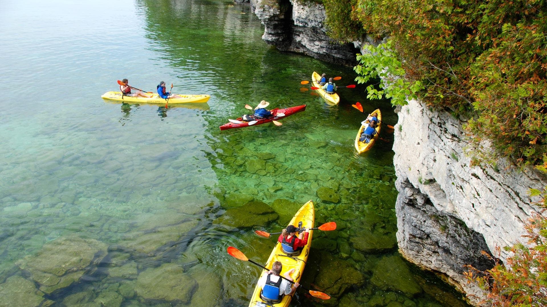 Kayaks exploring limestone cliffs and clear coastal waters