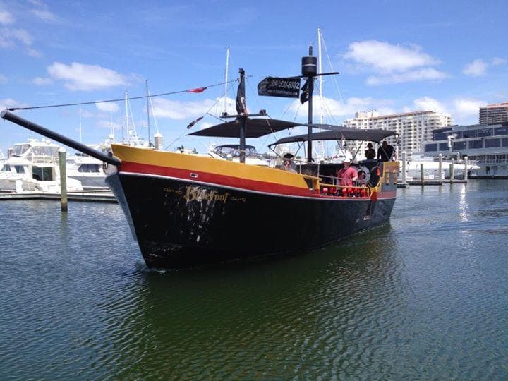 Black-and-yellow pirate boat moored at marina for harbor tours