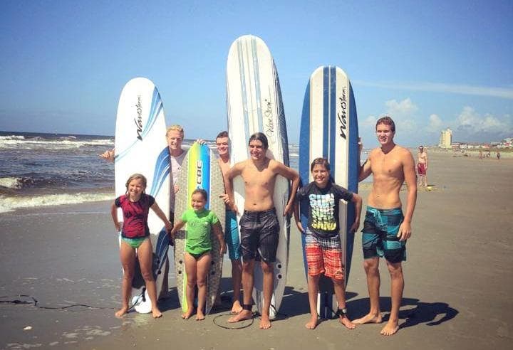 Group surf lesson with surfboards on sunny North Carolina beach