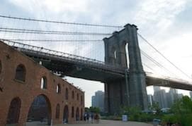 Brooklyn Bridge stone arches over East River with skyline