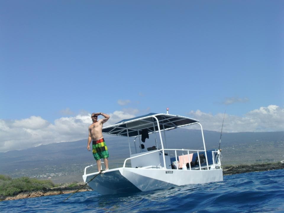 Tour boat with guide on calm ocean waters off Hawaiian coastline